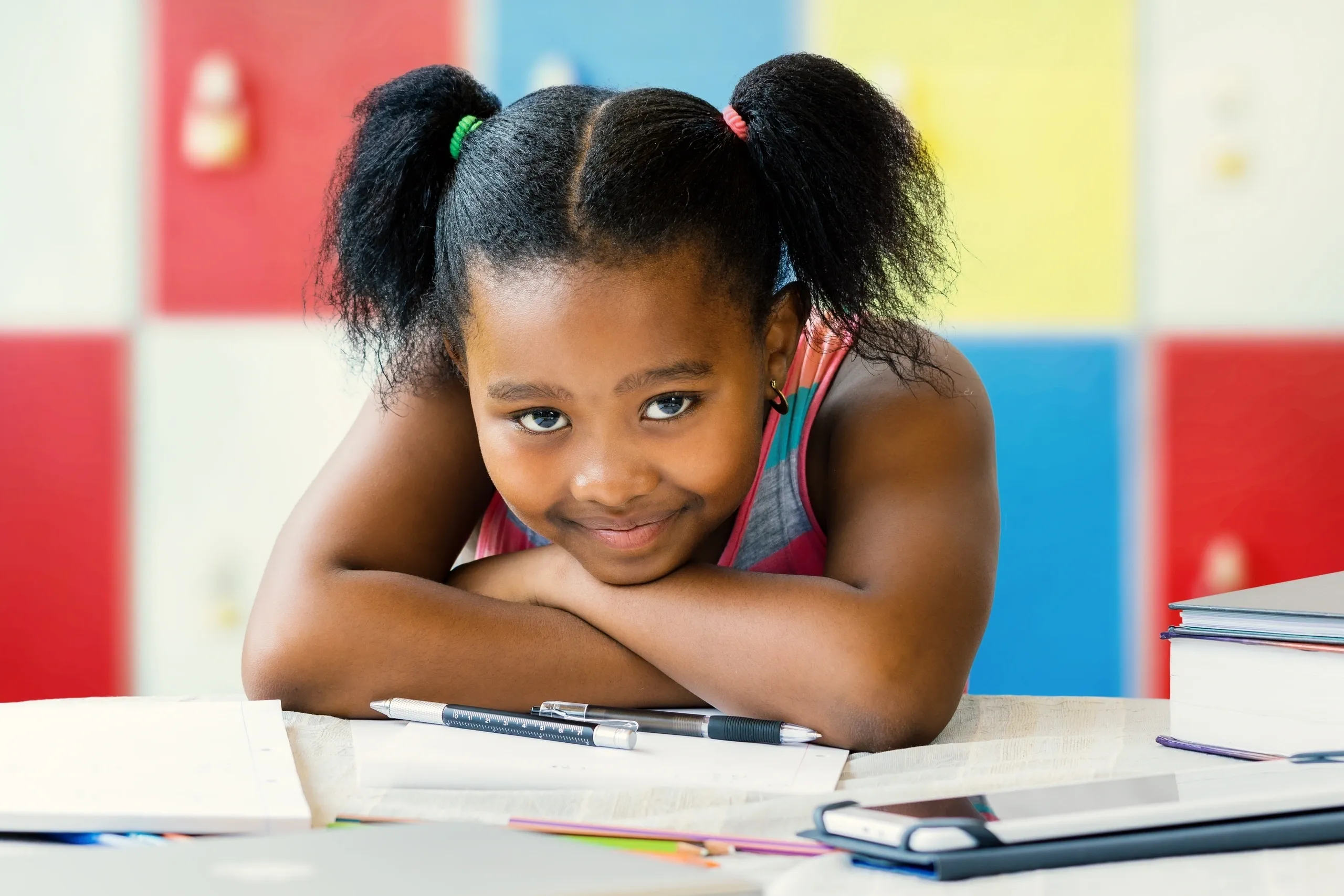 Young student sitting at a desk with books and learning materials